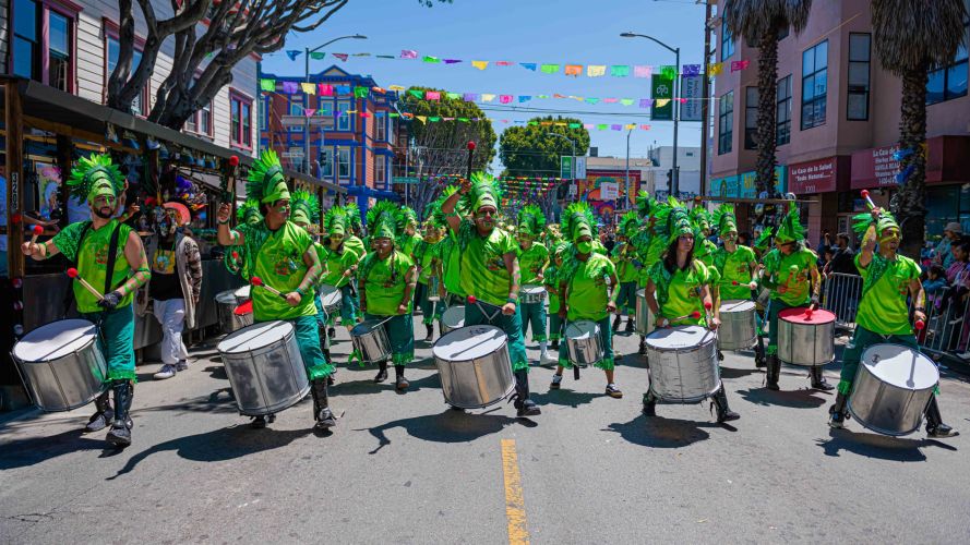 CANA SF - Cultura y Arte Nativa de las Americas - Fogo Na Rouge performing in the Carnaval San Francisco Grand Parade in their bright green costumes and large drums.